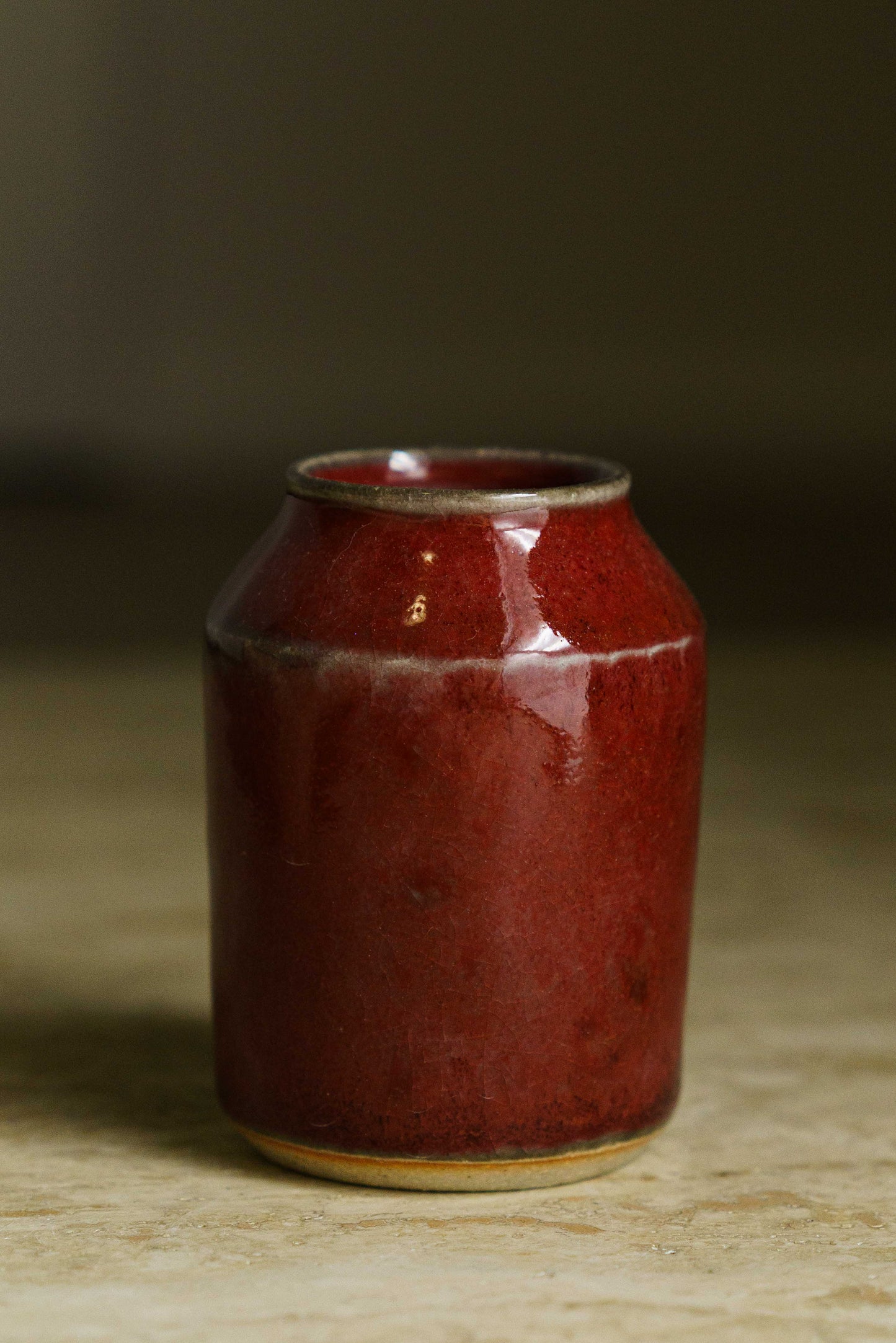 Small angular vase in red with white along the angle and rim.