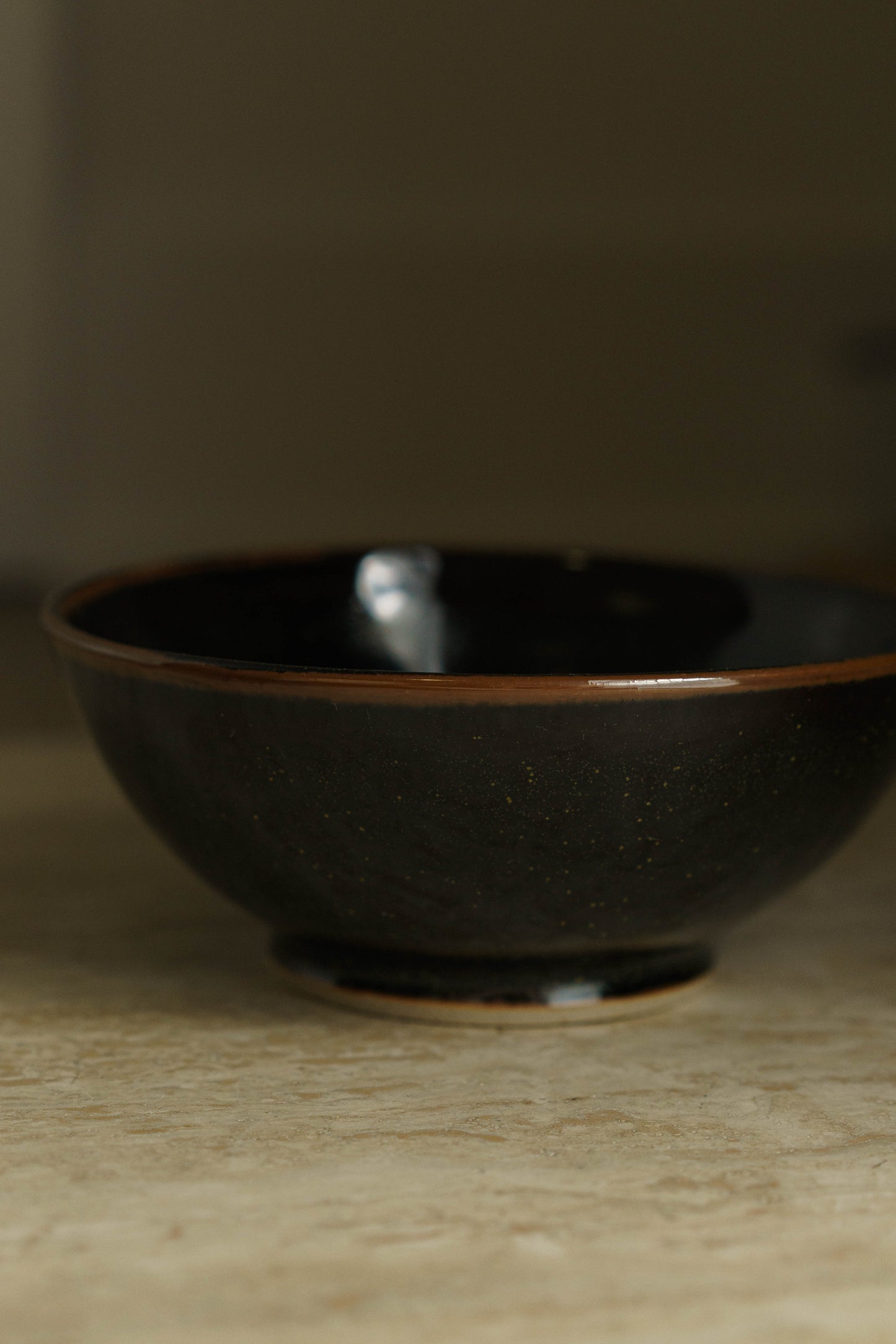 Black bowl with green flecks.