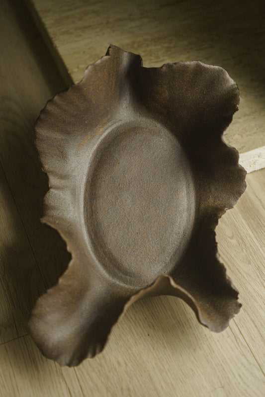 Large brown ceramic bowl, bare clay, with wavy ridges as rim