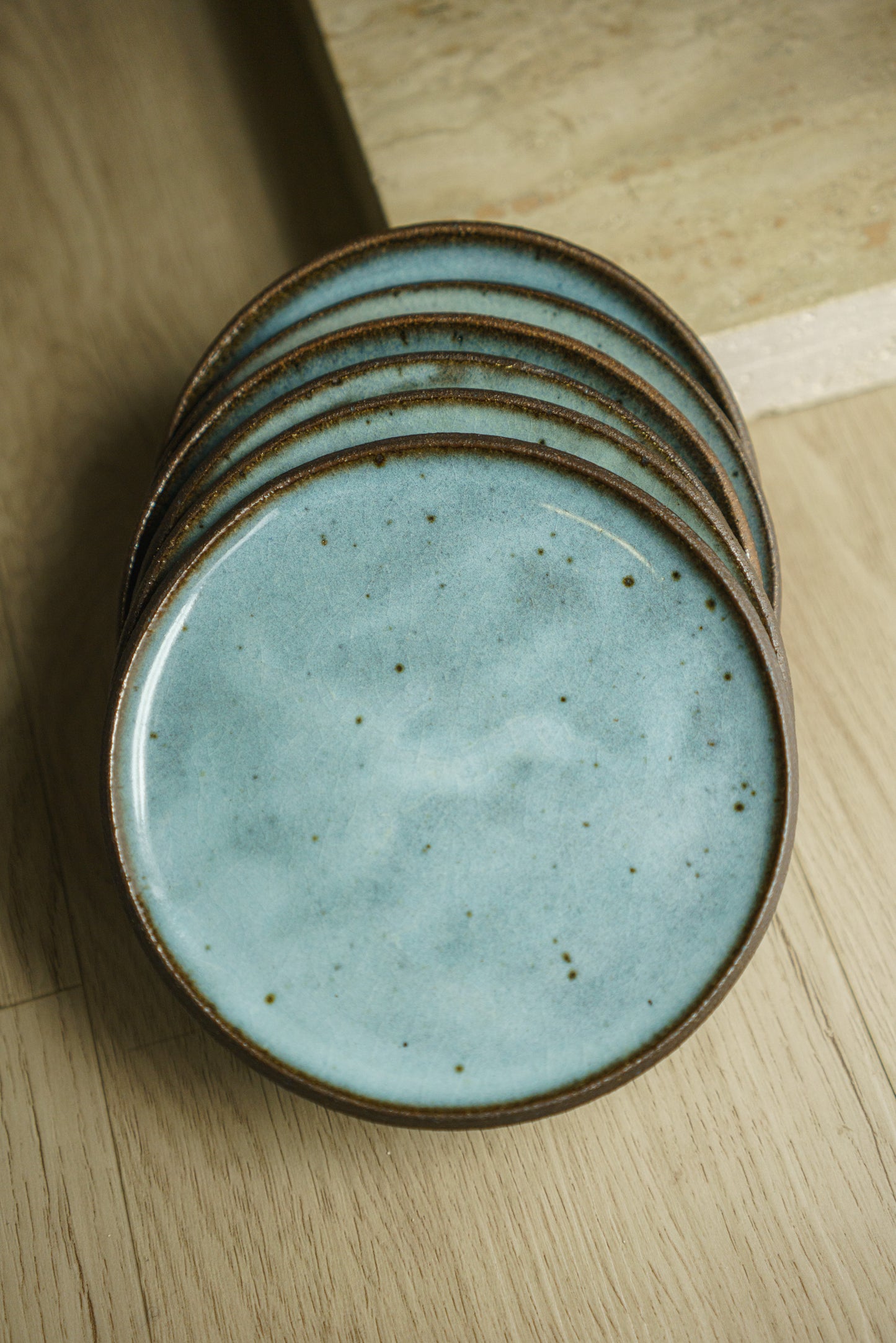6 stacked ceramic plates, brown base with blue/white glaze