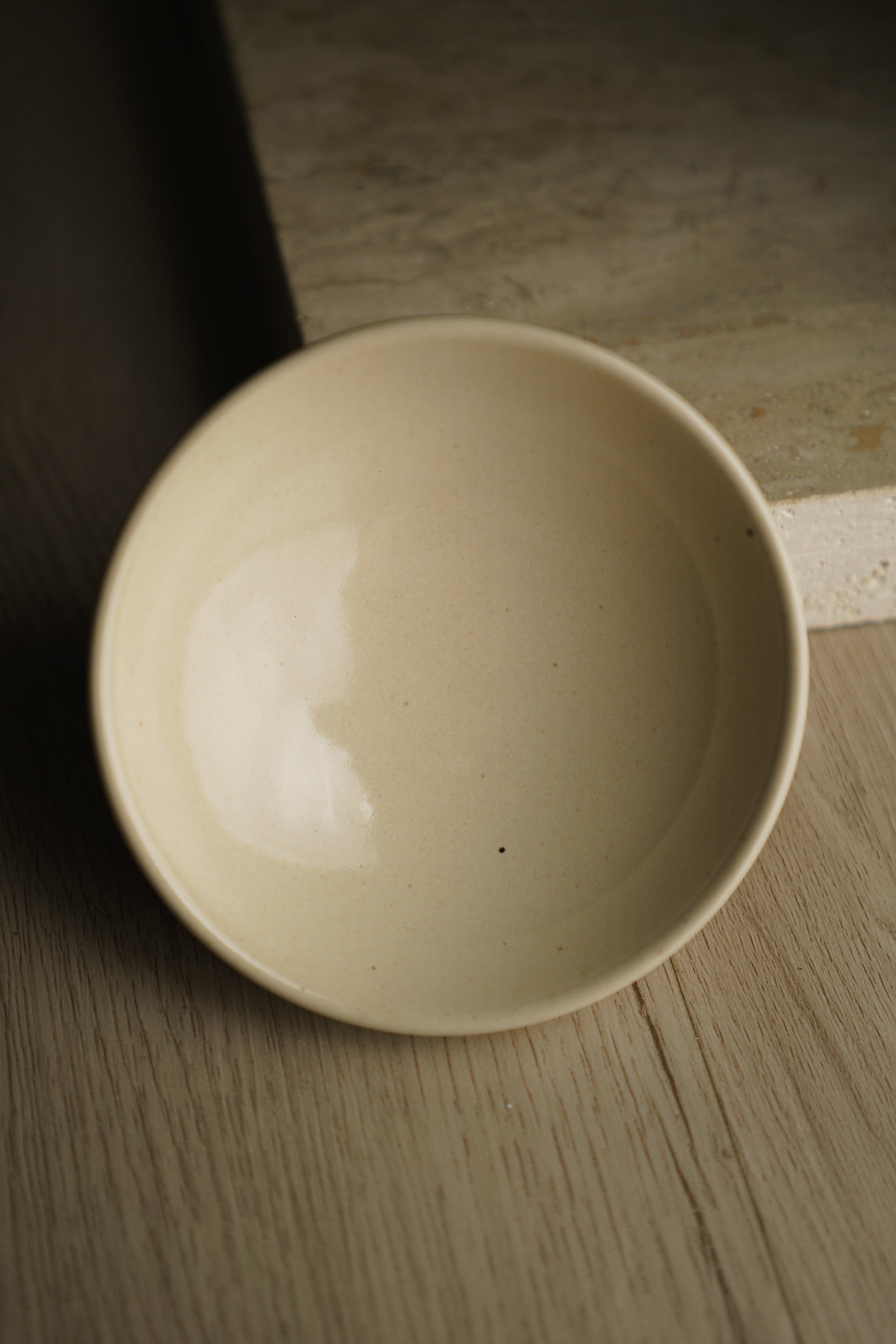 Beige ceramic bowl on a wooden surface