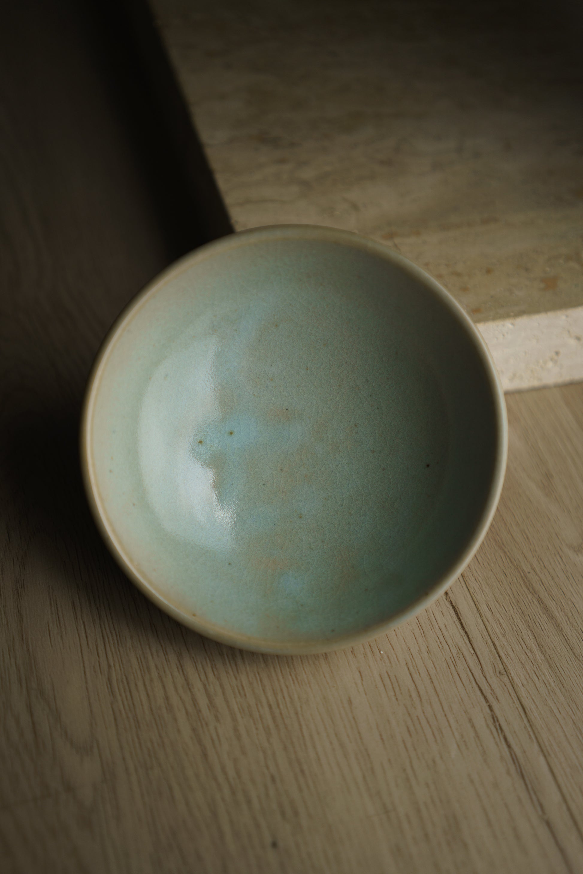 baby blue ceramic bowl on wooden floor