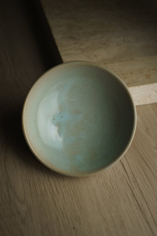 baby blue ceramic bowl on wooden floor
