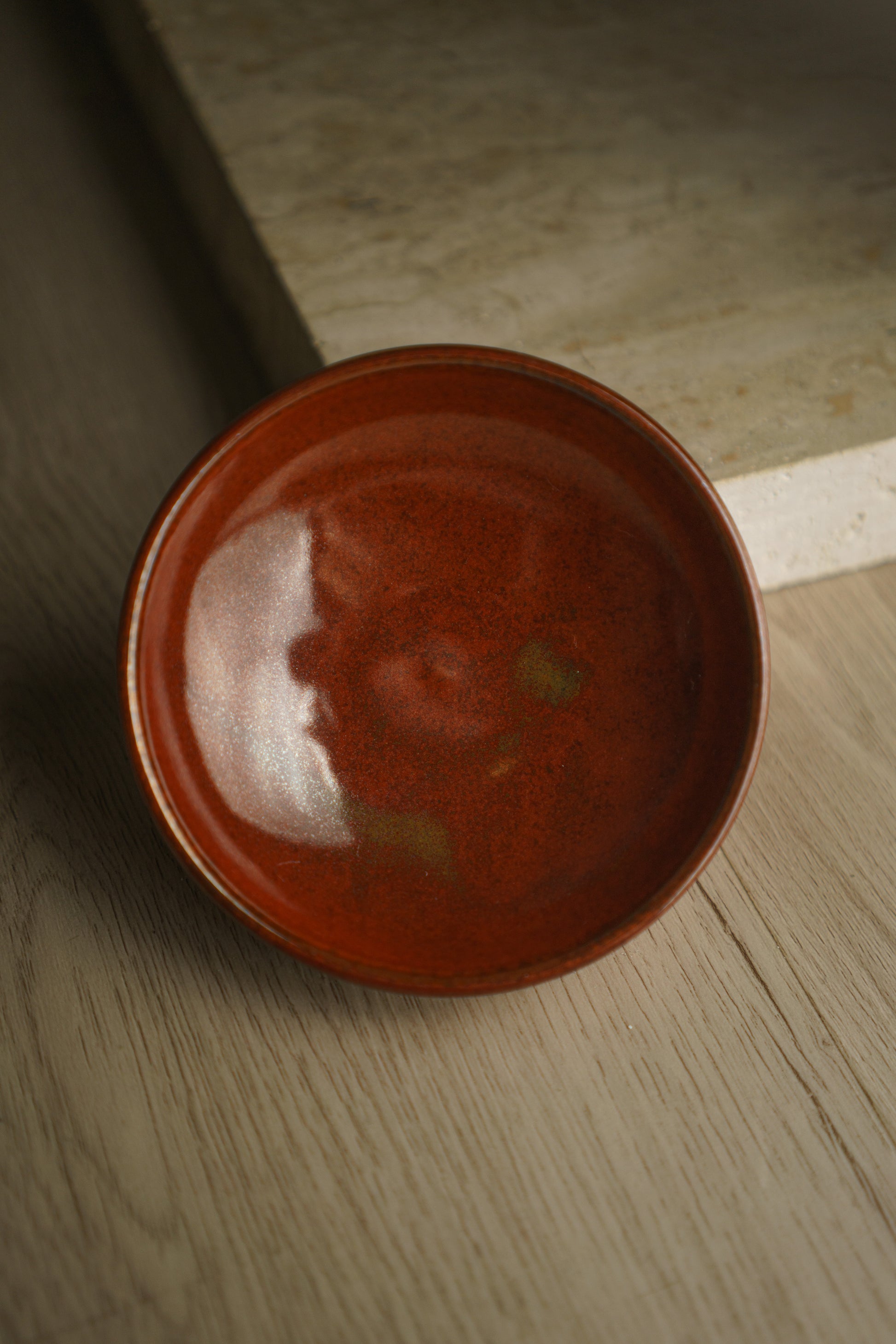 red ceramic bowl with tinges of green/yellow