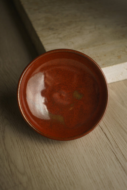 red ceramic bowl with tinges of green/yellow