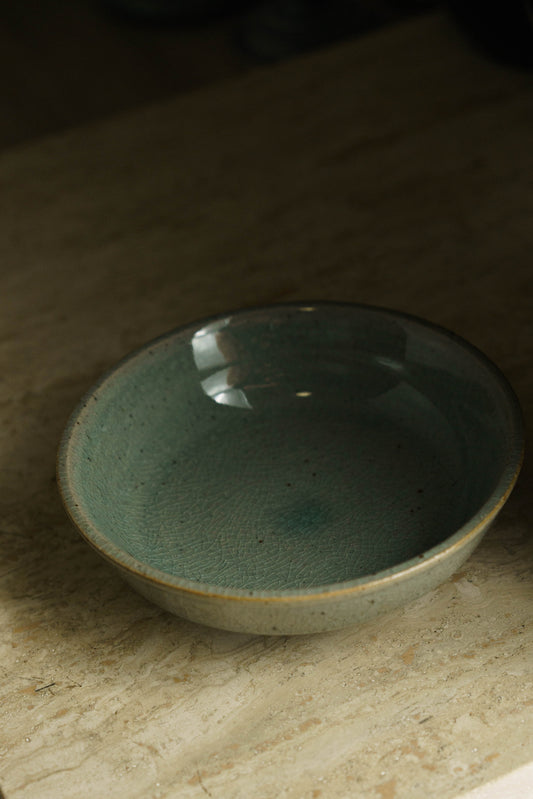 Celadon ceramic bowl with flat center and shallow lips