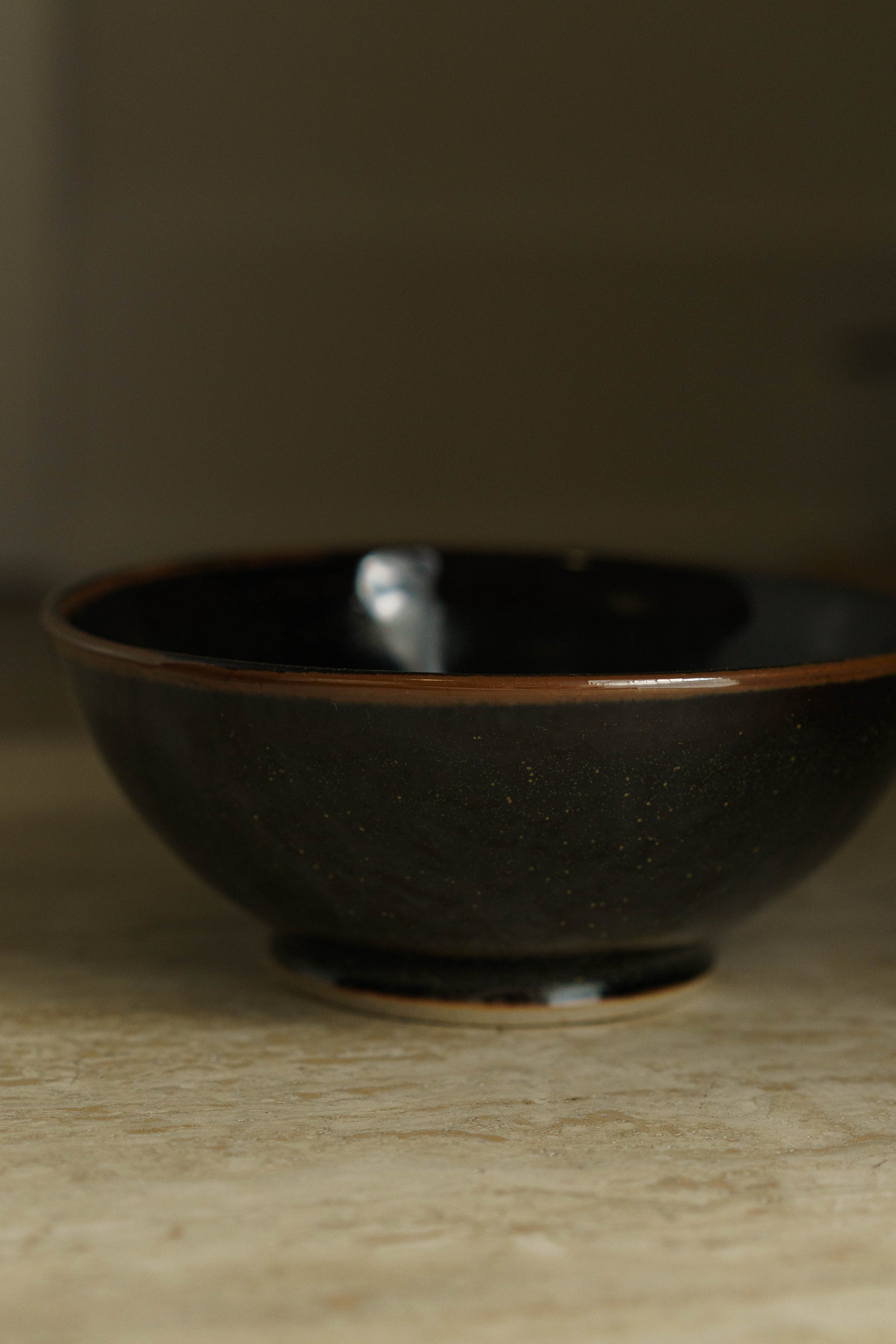 Black bowl with green flecks.