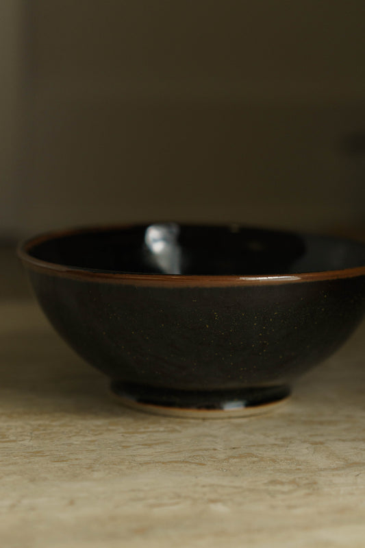 Black bowl with green flecks.